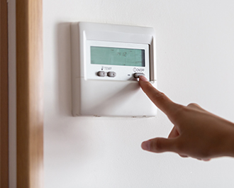 Person adjusting thermostat